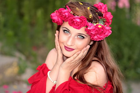 woman wears red off-shoulder shirt with red flower headdress thumbnail