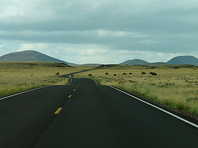 asphalt road beside grass field and mountain at daytime thumbnail