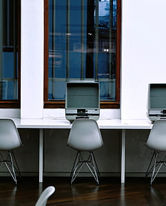 gray flat screen monitor on desk in front gray steel chair thumbnail