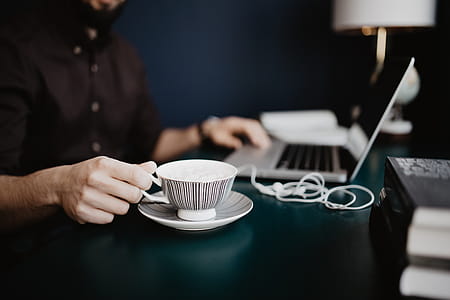 Male working with a laptop and a cup of coffee thumbnail