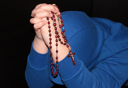 person holding praying rosary thumbnail