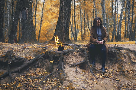 woman sitting on brown tree roots thumbnail
