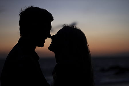silhouette of couple kissing near body of water thumbnail