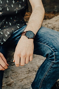 man sitting on brown branch during daytime thumbnail