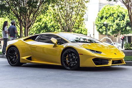 yellow Lamborghini Huracan supercar parked near two men standing thumbnail