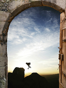 silhouette of person jumping off the cliff during sunrise photo view from dome gray concrete entrance thumbnail