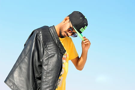 Man Holding His Black And Green Flat-brimmed Cap thumbnail