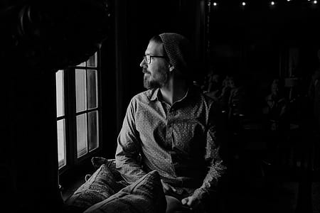 greyscale photography of man near window thumbnail