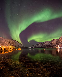 body of water in the middle of mountains during night time thumbnail