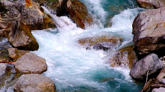 blue and white waterfall beside rocks thumbnail