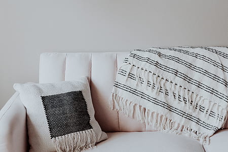 white throw pillow on top of white sofa thumbnail