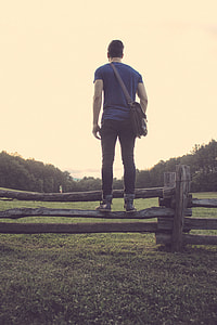 man standing on wooden fence thumbnail
