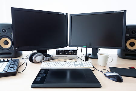 two black flat screen computer monitor on white table thumbnail
