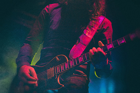 man playing with guitar low light photography thumbnail