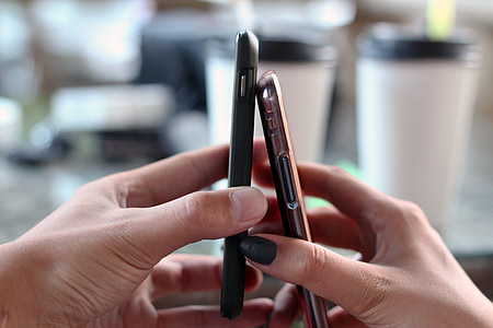 person holding black and brown Android smartphones thumbnail