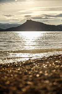 body of water across mountain during daytime thumbnail