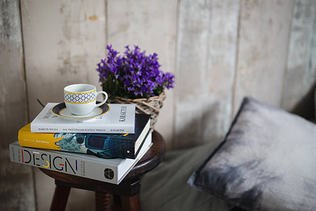 Books and purple flowers on a wooden stool by the bed thumbnail