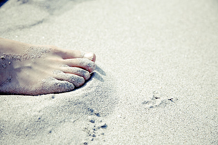 person's right foot in gray sand during daytime thumbnail