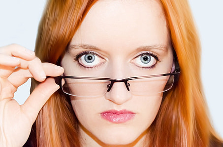 woman wearing red lipstick putting her eyeglass half-down thumbnail