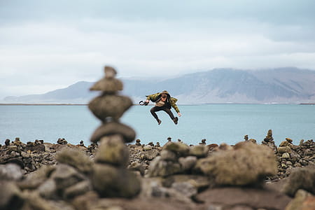 A young caucasian hiker on a stoney shore of a mountain lake thumbnail