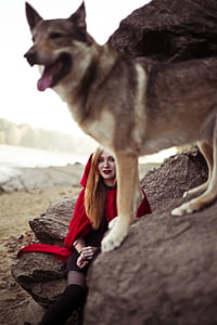 girl in red short-sleeved shirt sitting on brown rock thumbnail