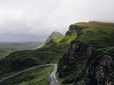 curved concrete road on mountain with green grasses thumbnail