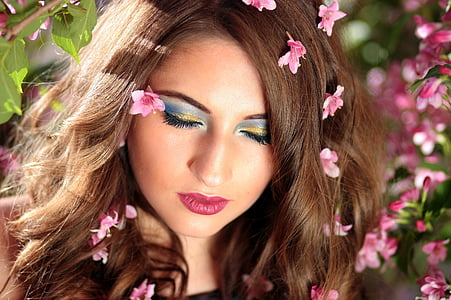 woman wearing blue mascara with pink flowers on her hair thumbnail