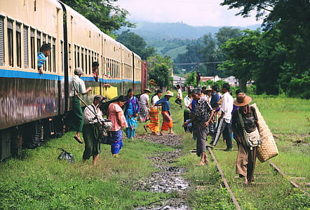 people getting out of train and walking on green grass field during daytime thumbnail