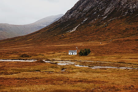 white and gray cabin below mountain during daytime thumbnail