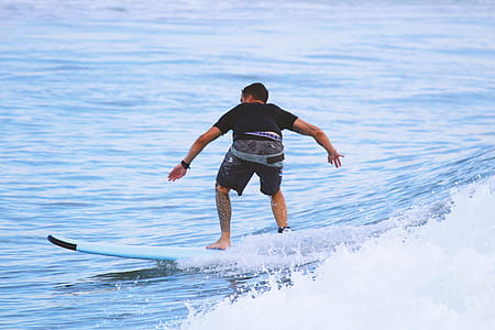 person riding on surfboard on body of water thumbnail