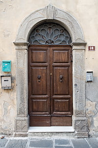 beige concrete building with brown wooden door thumbnail