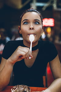 bokeh shot of woman licking white spoon thumbnail