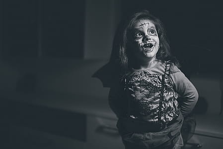 Grayscale Photo of Smiling Girl In Halloween Costume thumbnail