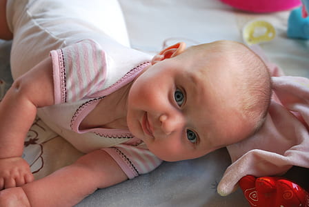 closeup photo of baby wearing white top on blue surface thumbnail