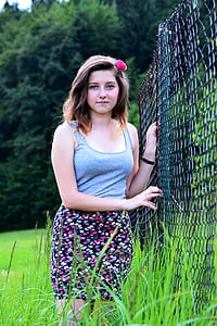 woman beside chain link fence standing at daytime thumbnail