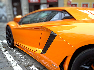 orange sports card parked on paver block thumbnail