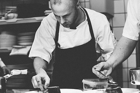 grayscale photo of man wearing apron thumbnail