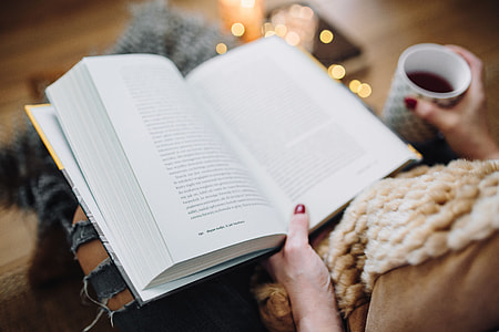 Woman drinking tea and reading book thumbnail