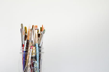 assorted paint brushes in clear glass jar thumbnail