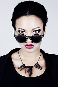 woman with black scoop-neck shirt, black pendant necklace, and black sunglasses thumbnail