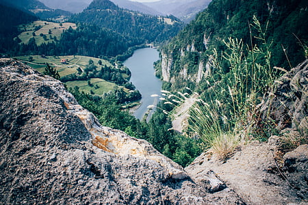 aerial view of body of water surrounded by mountains thumbnail