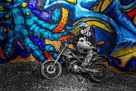 person riding on dirt bike leaning beside wall thumbnail
