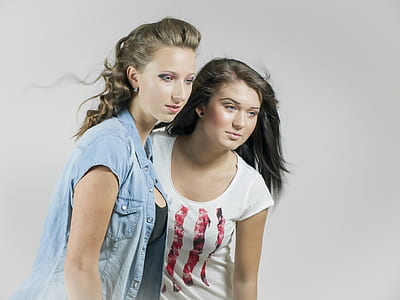 two woman wearing white shirt and blue denim button-up shirt thumbnail