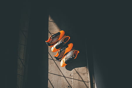 two pairs of orange Umbro cleats thumbnail