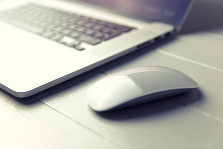 Macbook Pro laptop in light on a white wood desk thumbnail