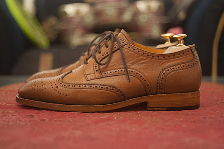 pair of brown leather wingtip shoes on red textile thumbnail
