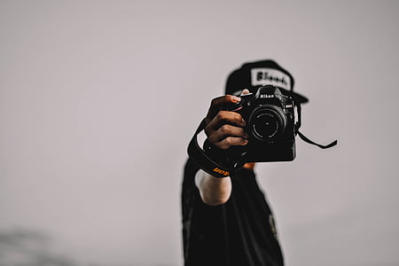 person holding black Nikon DSLR camera thumbnail