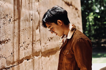 man standing in front of the wall while looking down thumbnail