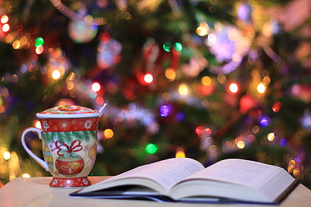 red and green ceramic mug near book on table thumbnail