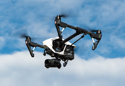 black and white quadcopter drone flying under cloudy sky during daytime thumbnail